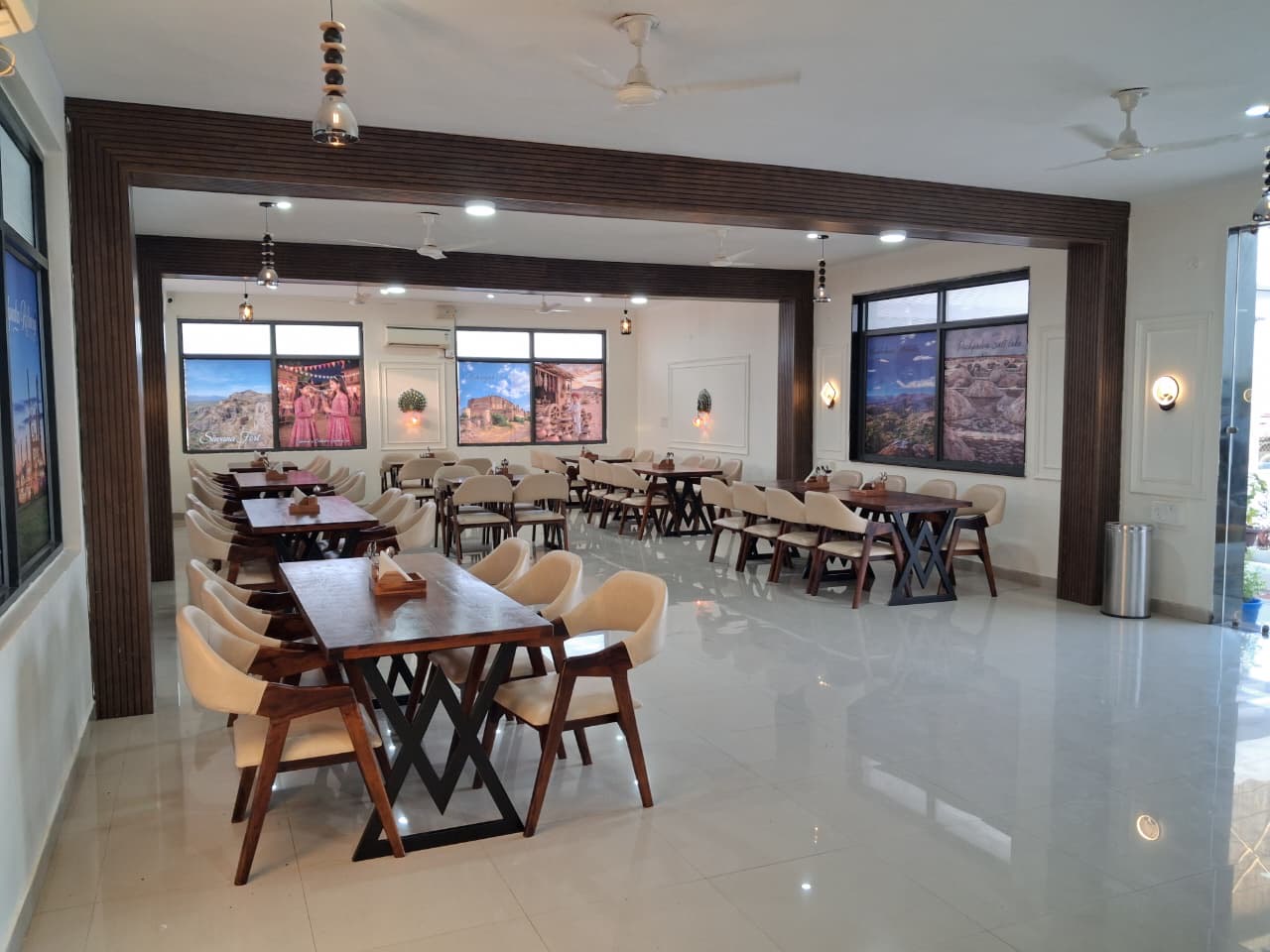 AC family restaurant hall at Guru Kripa, Pachpadra, with walnut tables and cream chairs
